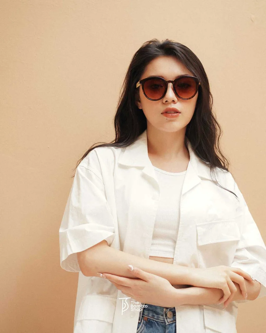 A woman wearing round wooden sunglasses